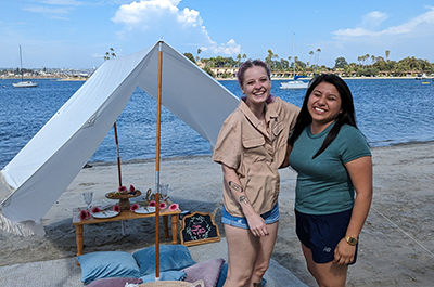 a couple picnicing in front of a body of water