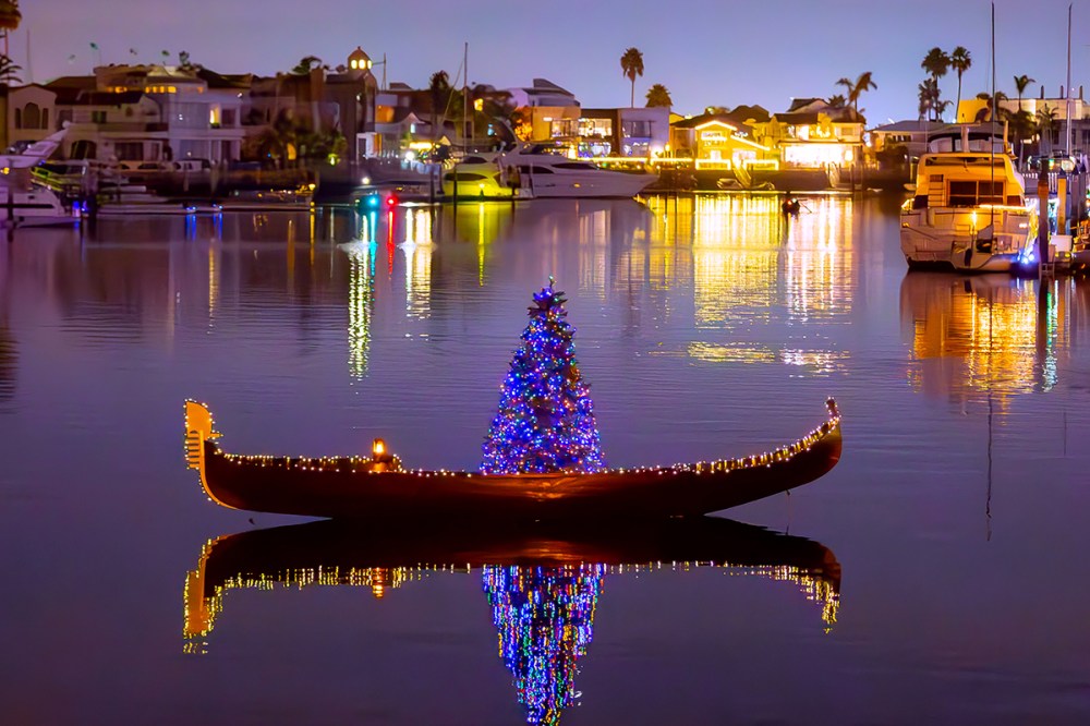 Gondola decorated with Christmas lights and a glowing holiday tree cruising through the Coronado Cays during The Gondola Company’s Holiday Gondola Cruise.