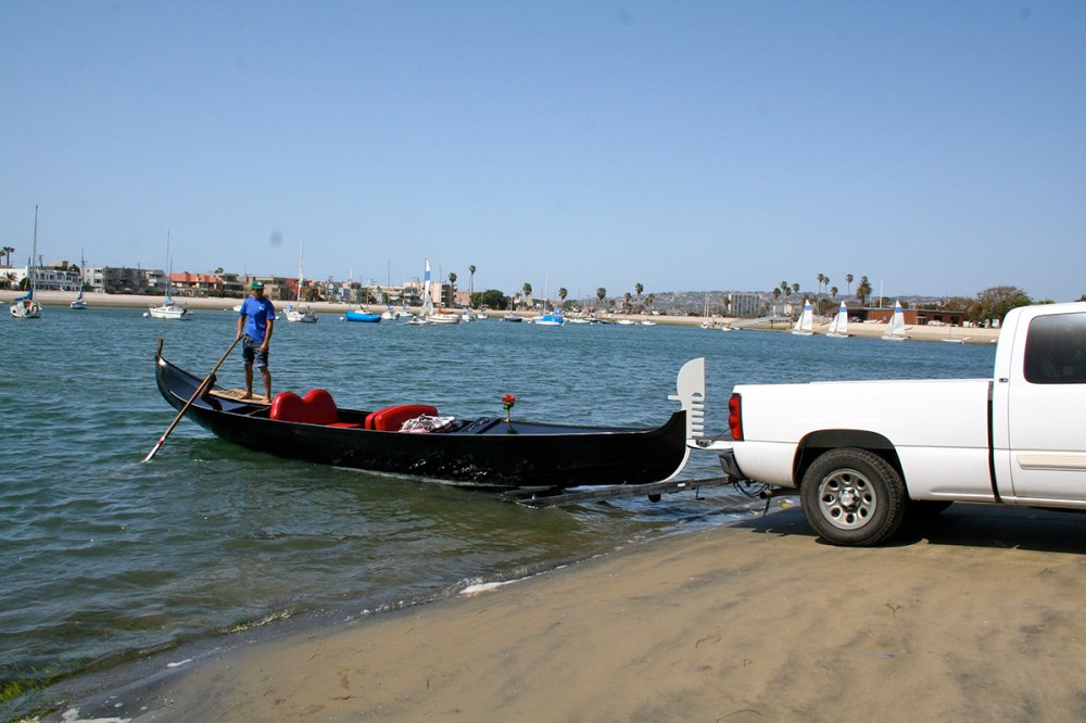 Gondola rental being launched from a truck trailer into the water with gondolier. Perfect for parties, events, and waterfront celebrations.