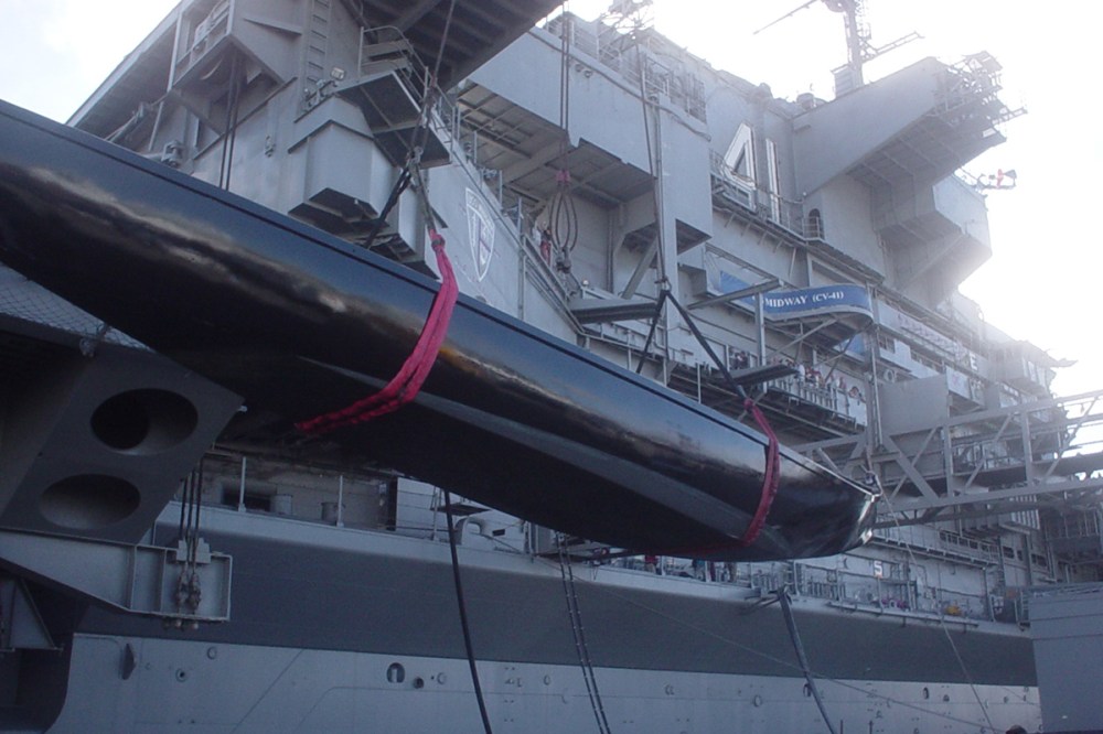 A gondola prop being hoisted by crane onto the Midway Museum for a wedding decoration.