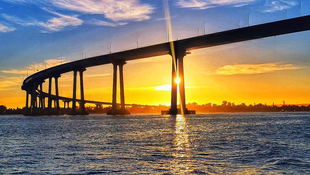 Coronado Bridge and San Diego Bay illuminated by the sunset sky.