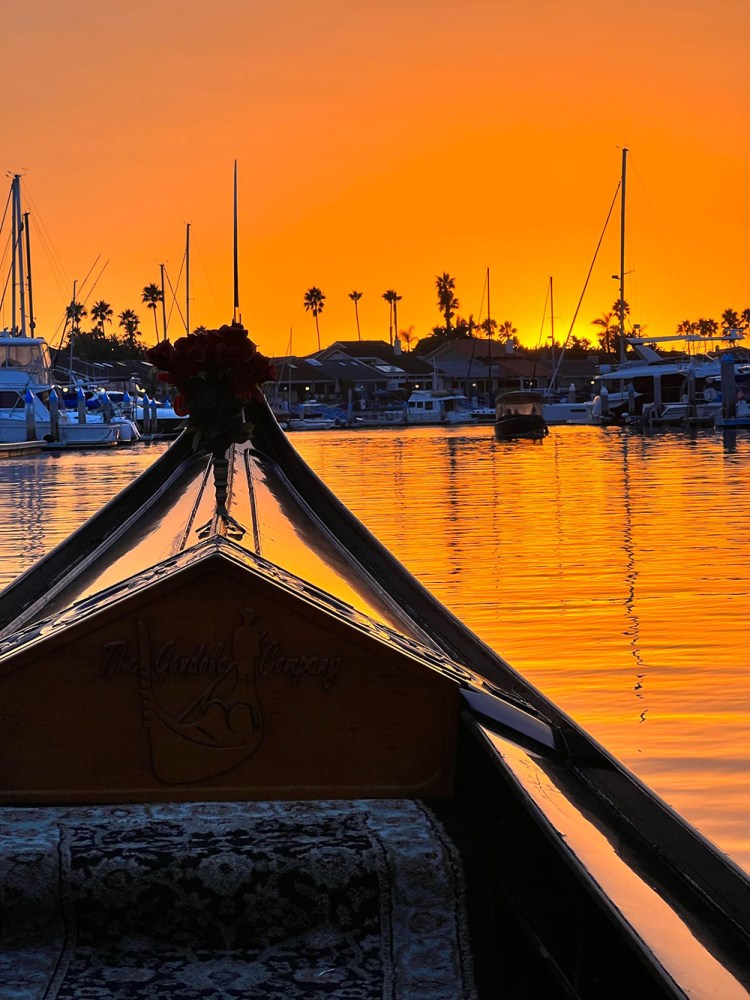 Gondola cruising toward an orange sunset sky in Coronado.