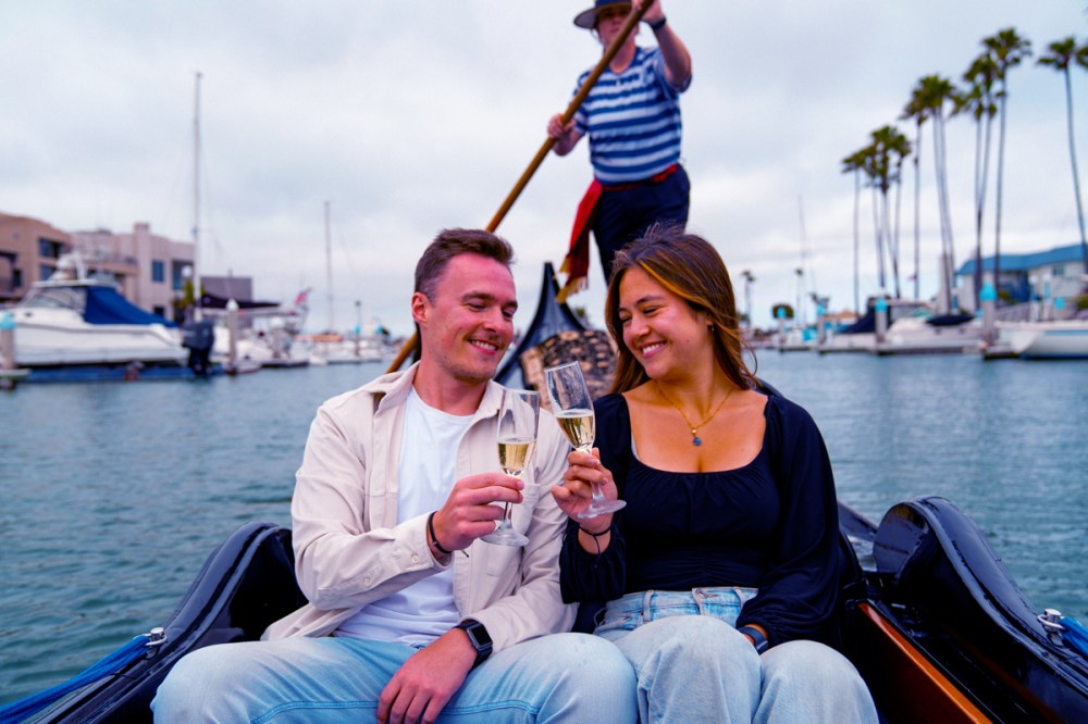 Couple toasting champagne during a romantic gondola ride in San Diego on their honeymoon