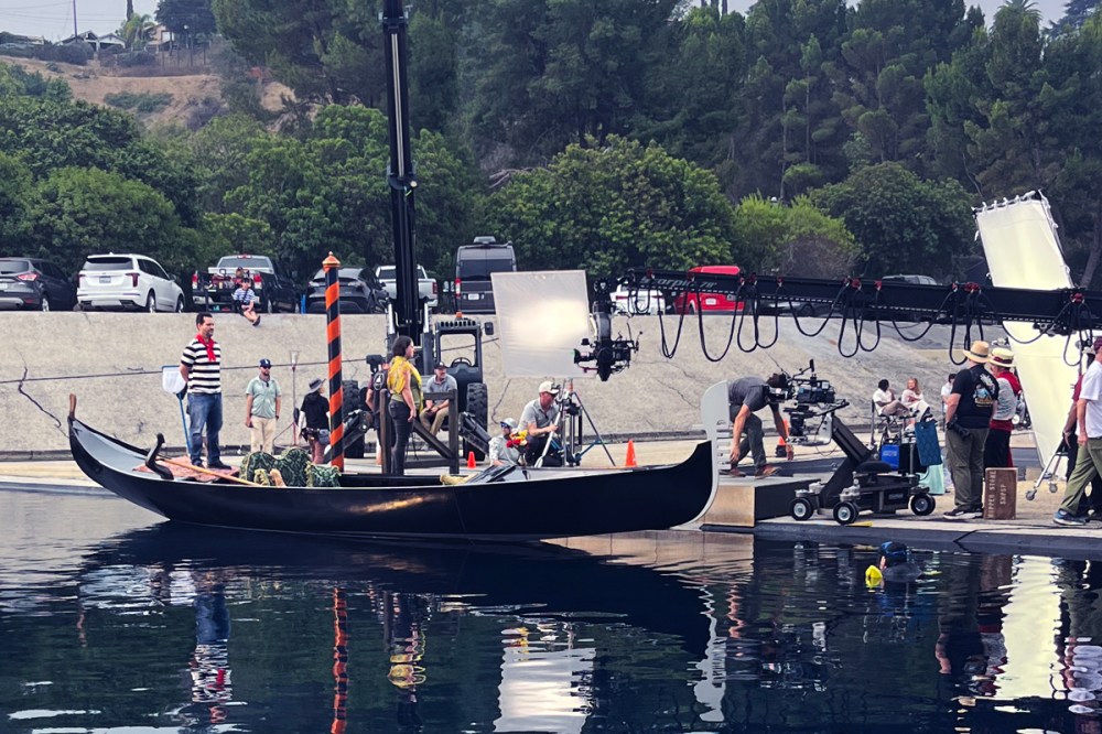 Gondola with two actors surrounded by film crew and cameras during a studio production